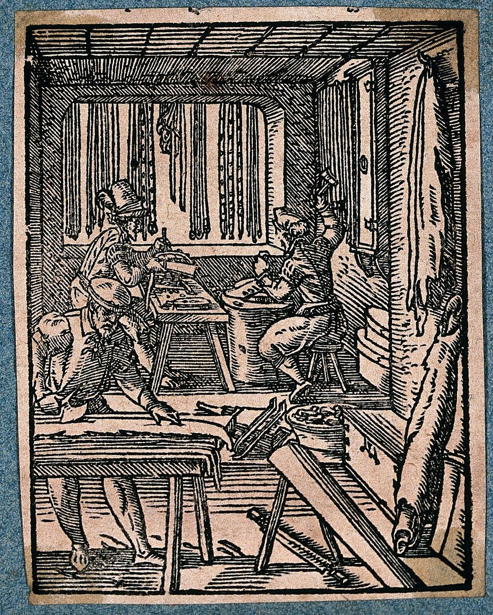 Makers of leather belts at work in their workshop. Woodcut by J. Amman.