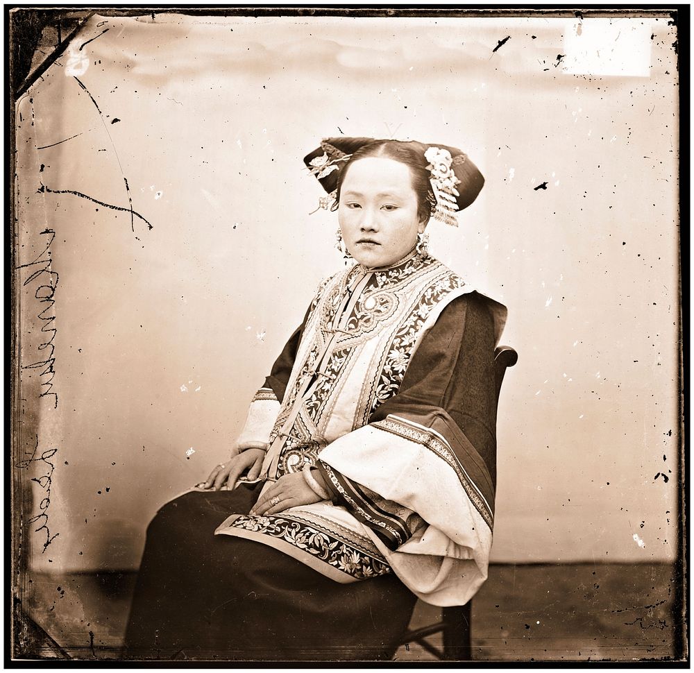 Peking, China: a seated Manchu lady wearing a coiffure. Photograph by John Thomson, 1869.