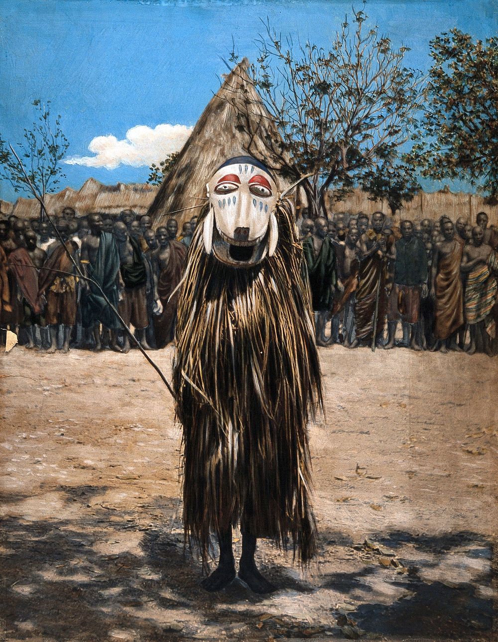 An African shaman or medicine man dressed in ritual mask and costume. Coloured photograph.