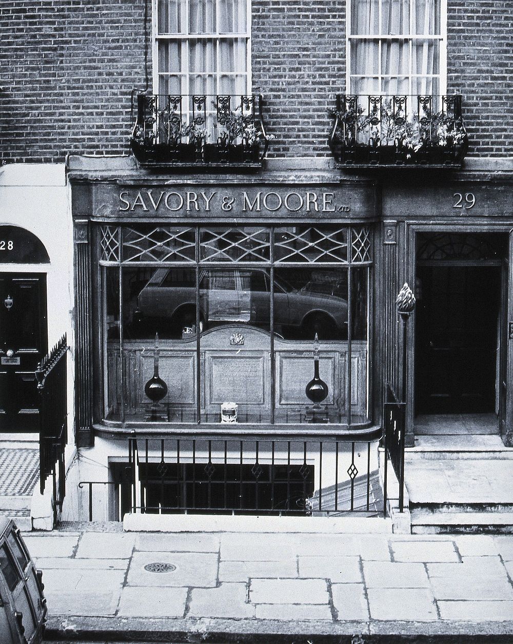 Savory & Moore Ltd, London: the window and front door of the pharmacy. Photograph.