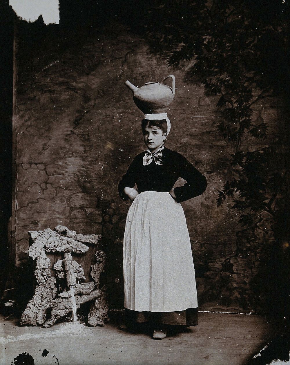 A Basque woman posing with an earthenware jug on her head.