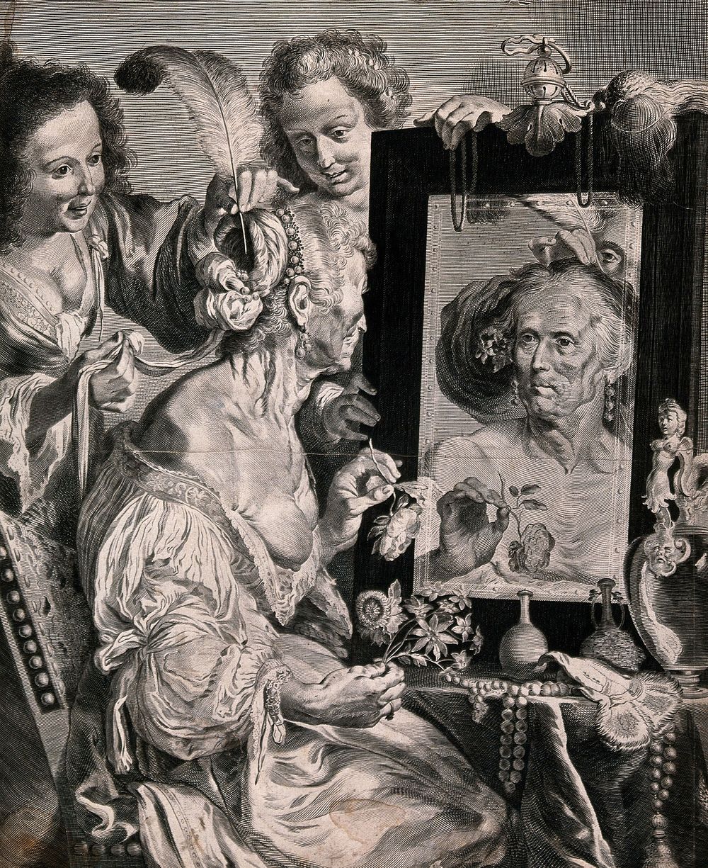 An old lady sitting at her dressing table mirror holding flowers, two younger women are putting feathers in her hair.…