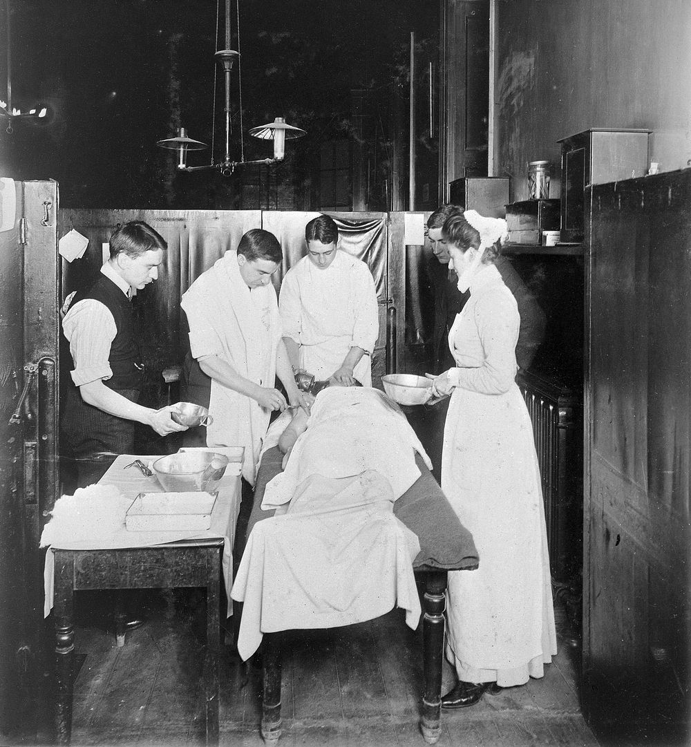 St Bartholomew's Hospital, London: patient undergoing treatment in the old surgery. Photograph, c.1908.