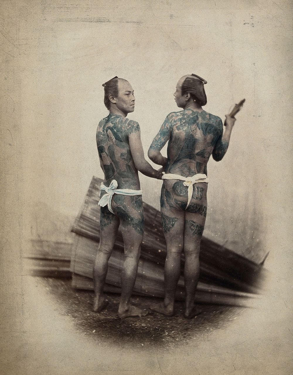 Japan: two men (bettoes or grooms) with elaborate tattoos. Coloured photograph.
