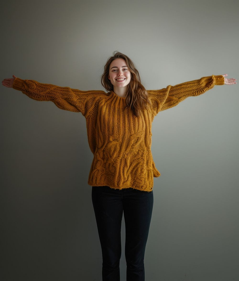Smiling woman in weater arms outstretched portrait sweater outerwear.