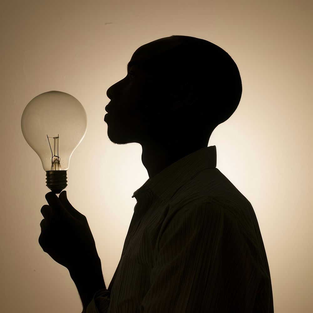 Person holding light bulb silhouette lightbulb lighting.