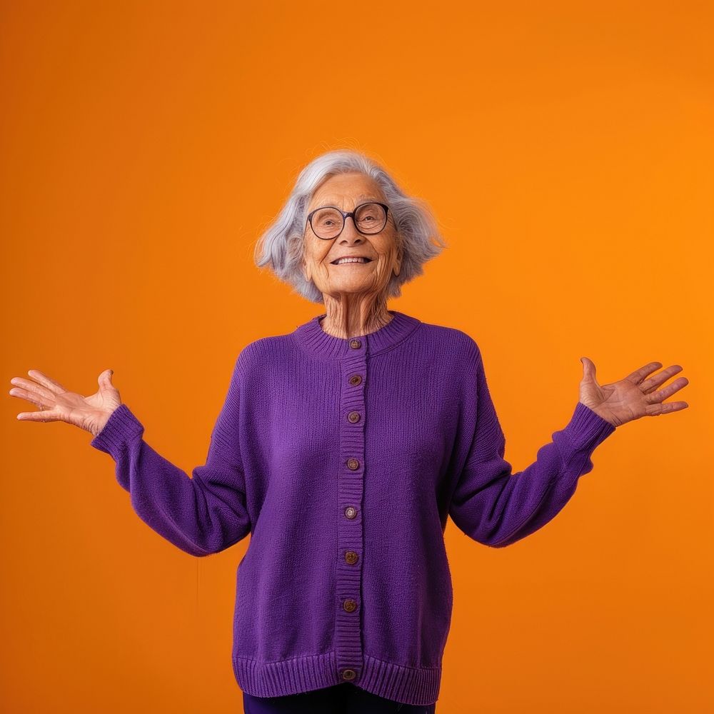 Old woman in purple sweater with her arms open adult orange background retirement.