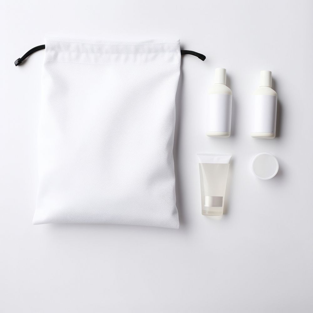 Blank white cotton flat drawstring pouch put on basin in the hotel bathroom bag bottle lotion.