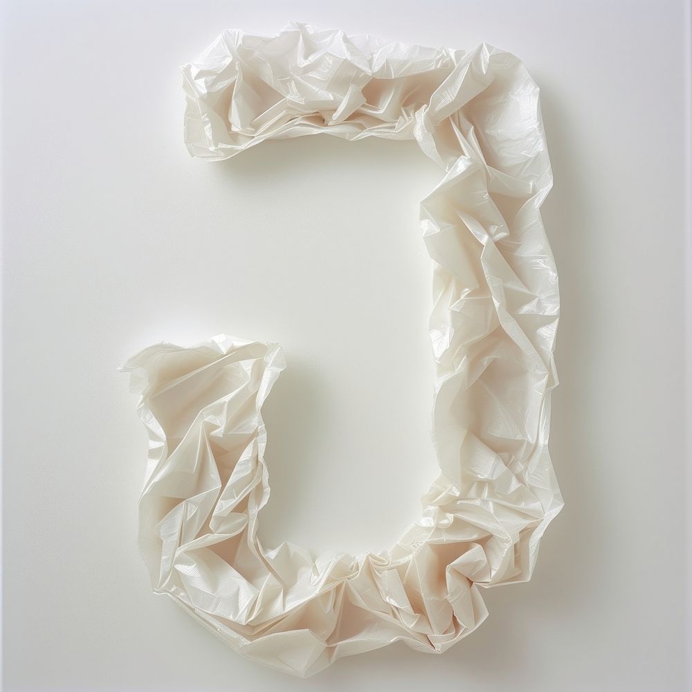 Plastic bag alphabet J white crumpled textile.