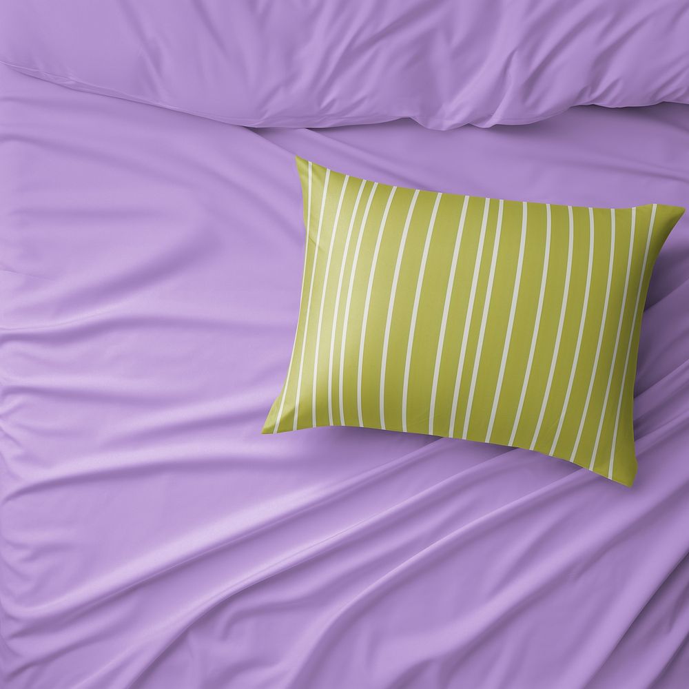 Olive green pillow on purple blanket