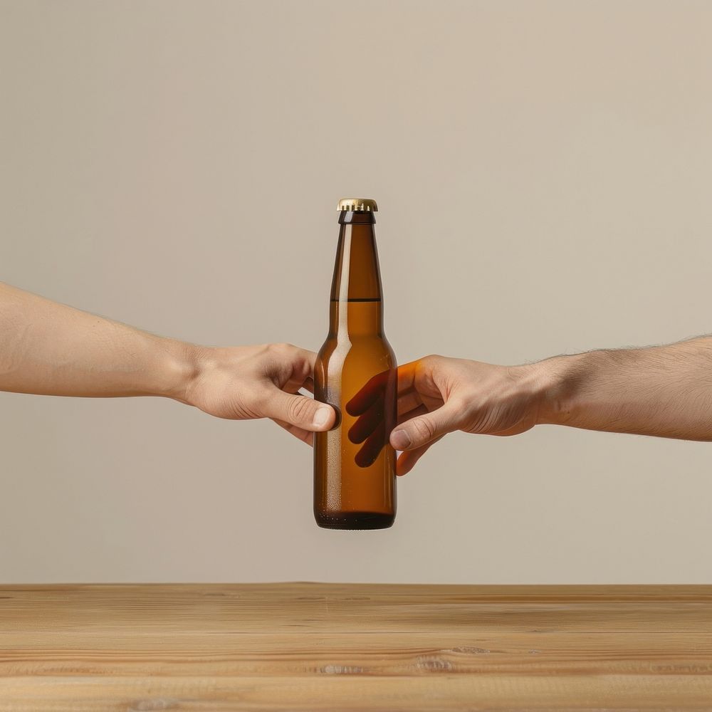 Two hands touching a beer bottle beverage alcohol liquor.
