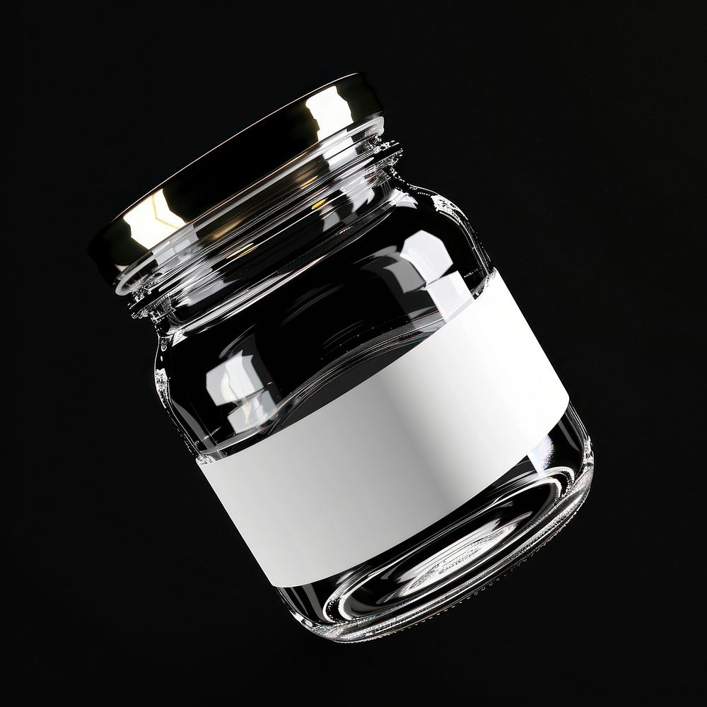 Clear jam jar bottle with white label black background container lighting.