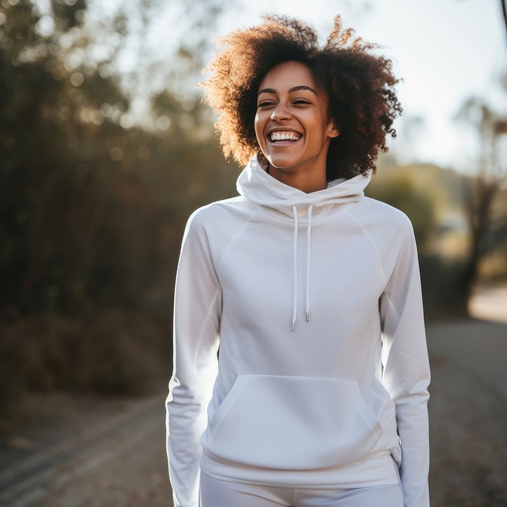 Black woman wearing white sport wear happy sweatshirt laughing.