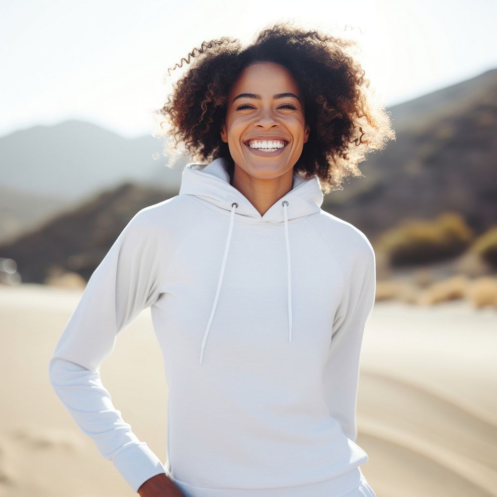 Black woman wearing white sport wear happy sweatshirt laughing.