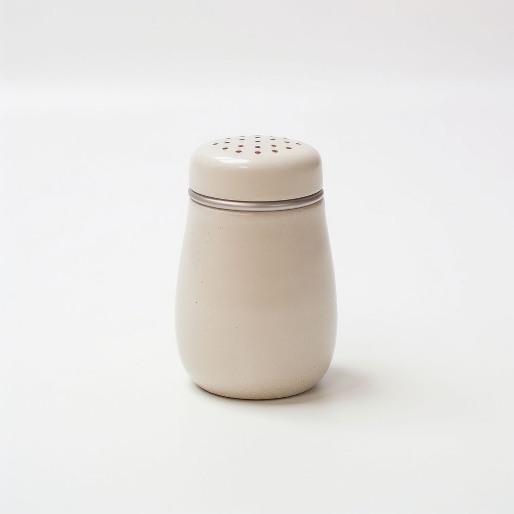 A beige salt shaker porcelain white background simplicity.