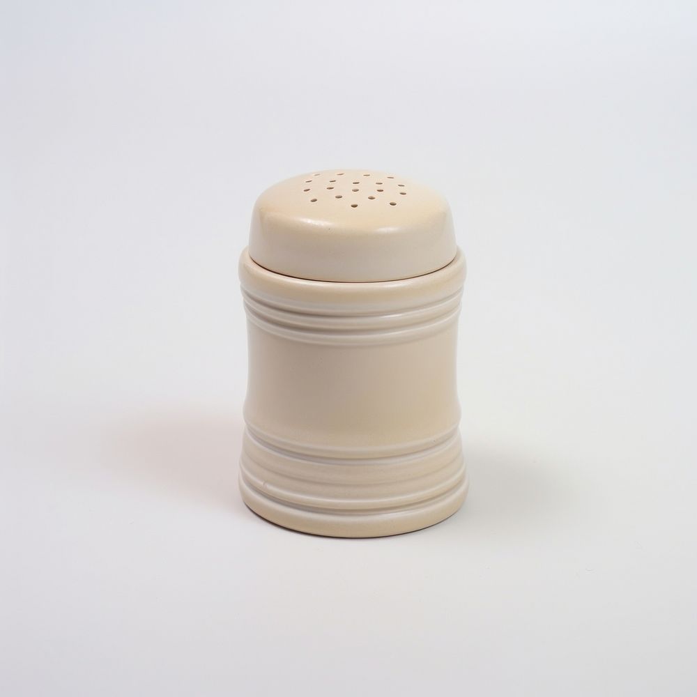 A beige salt shaker porcelain white background drinkware.