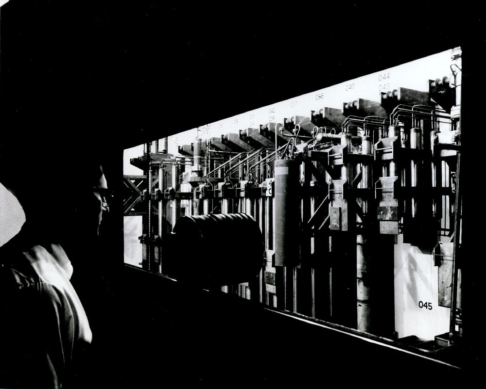 View, taken through several inch-thick shielding-glass, shows some of the process tanks used in the recovery of plutonium…