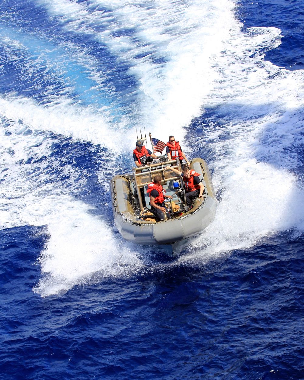 U.S. Sailors assigned to the amphibious transport dock ship USS Mesa Verde (LPD 19) maneuver a rigid-hull inflatable boat…