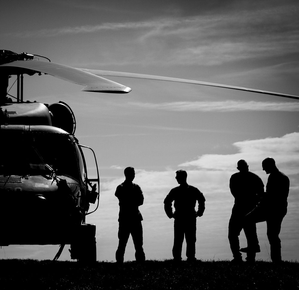 U.S. Army National Guard crew chiefs stand next to a 1-150th Assault Helicopter Battalion Black Hawk before a helicopter…