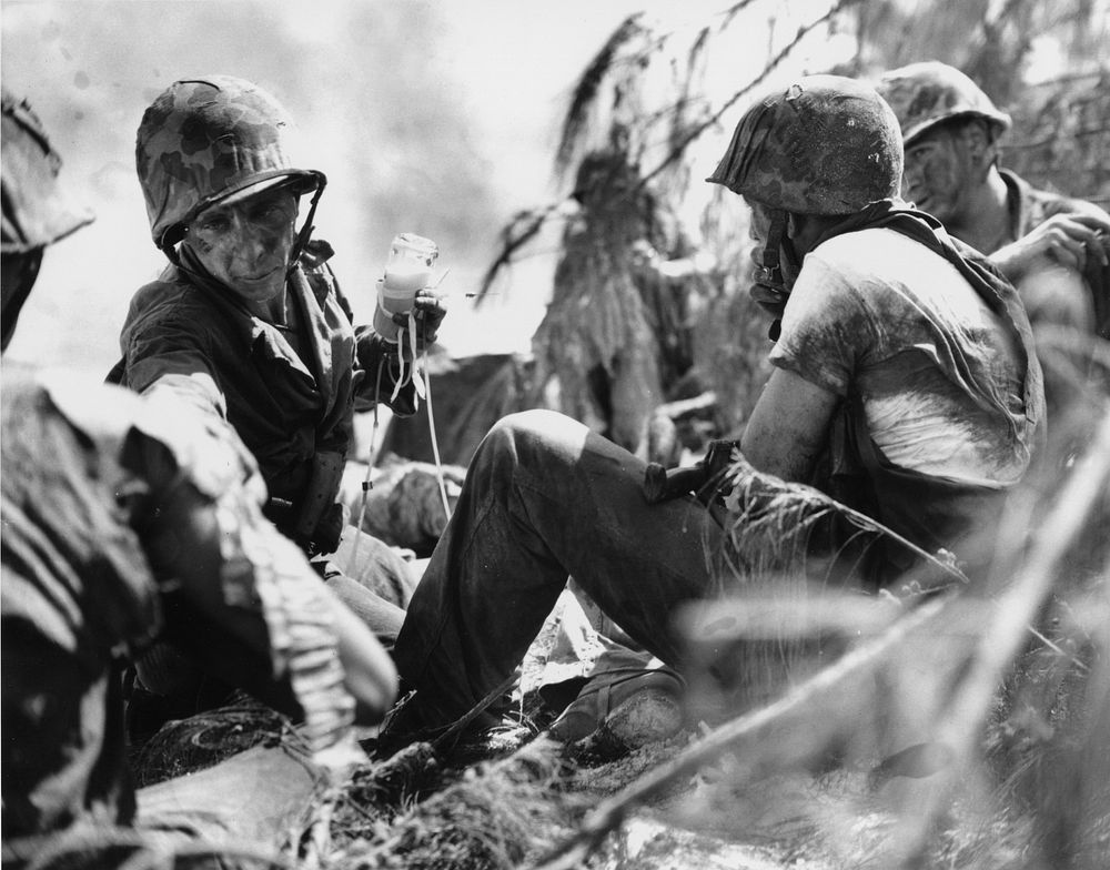 Corporal treating two wounded Marines on the beach during the World War 2. Headquarters Number 83573. Original public domain…