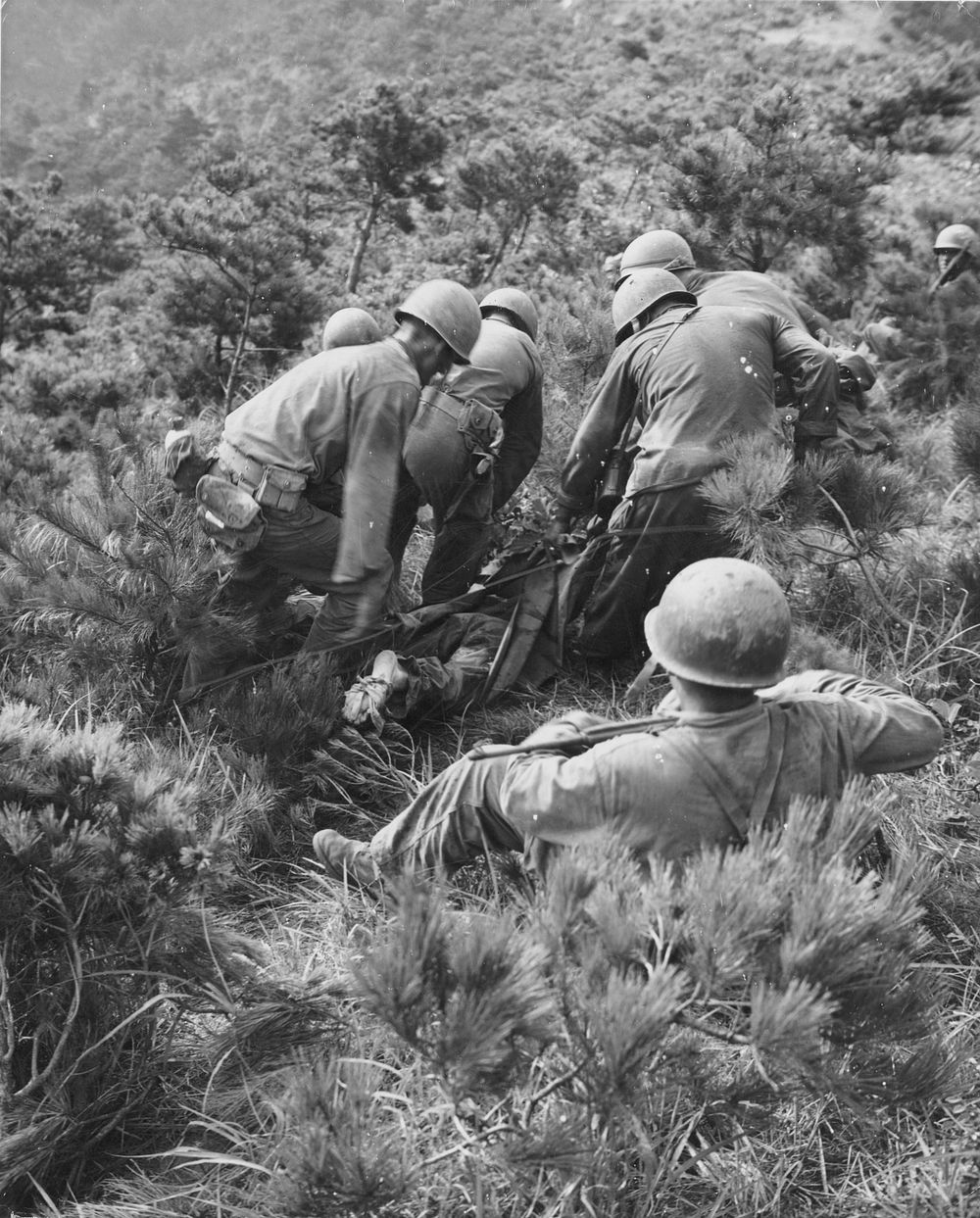 Marine wounded being carried from the front lines to a forward aid station. [Litters. Transport of sick and wounded.]…