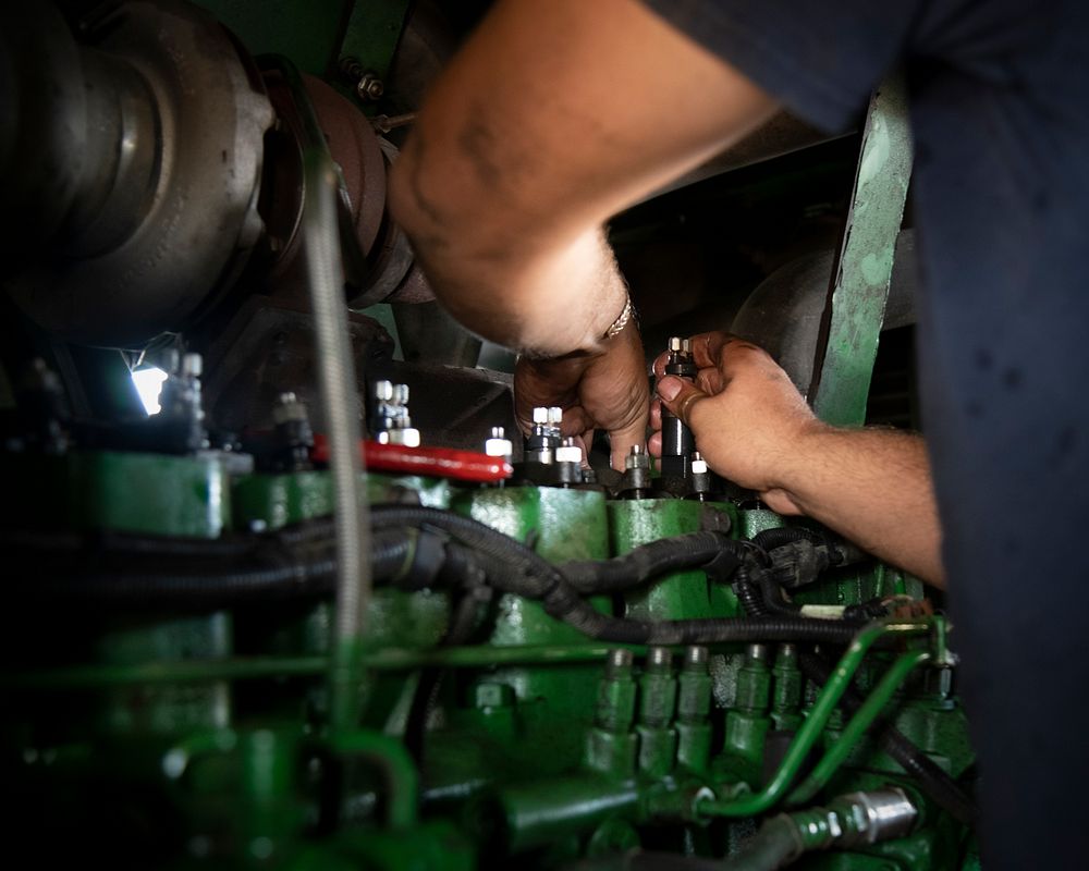 Brett Berstraeten works on his father's harvester engine in support of the Ernie Schirmer Farms cotton harvest, in…