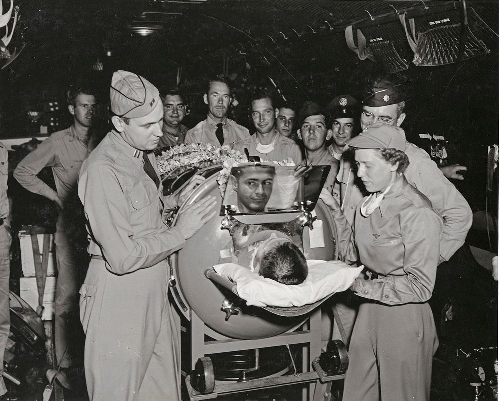 Iron lung patient, Robert Vande Zande, AK3, formerly stationed with Fasron 117 at Barbers Point is being briefed by Doctor…