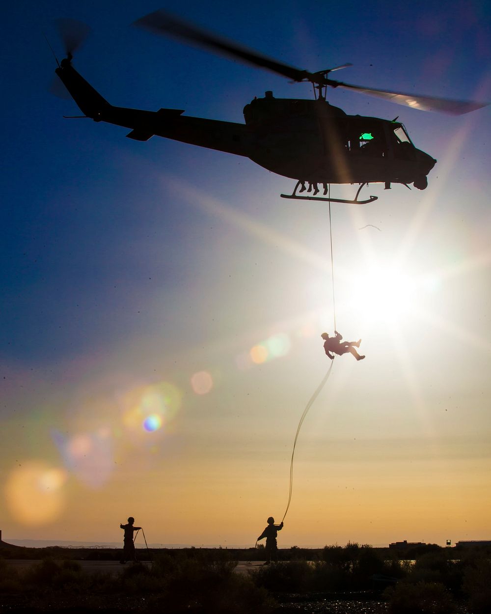A U.S. Marine, top, with the 26th Marine Expeditionary Unit's Maritime Raid Force rappels from a UH-1N Iroquois helicopter…