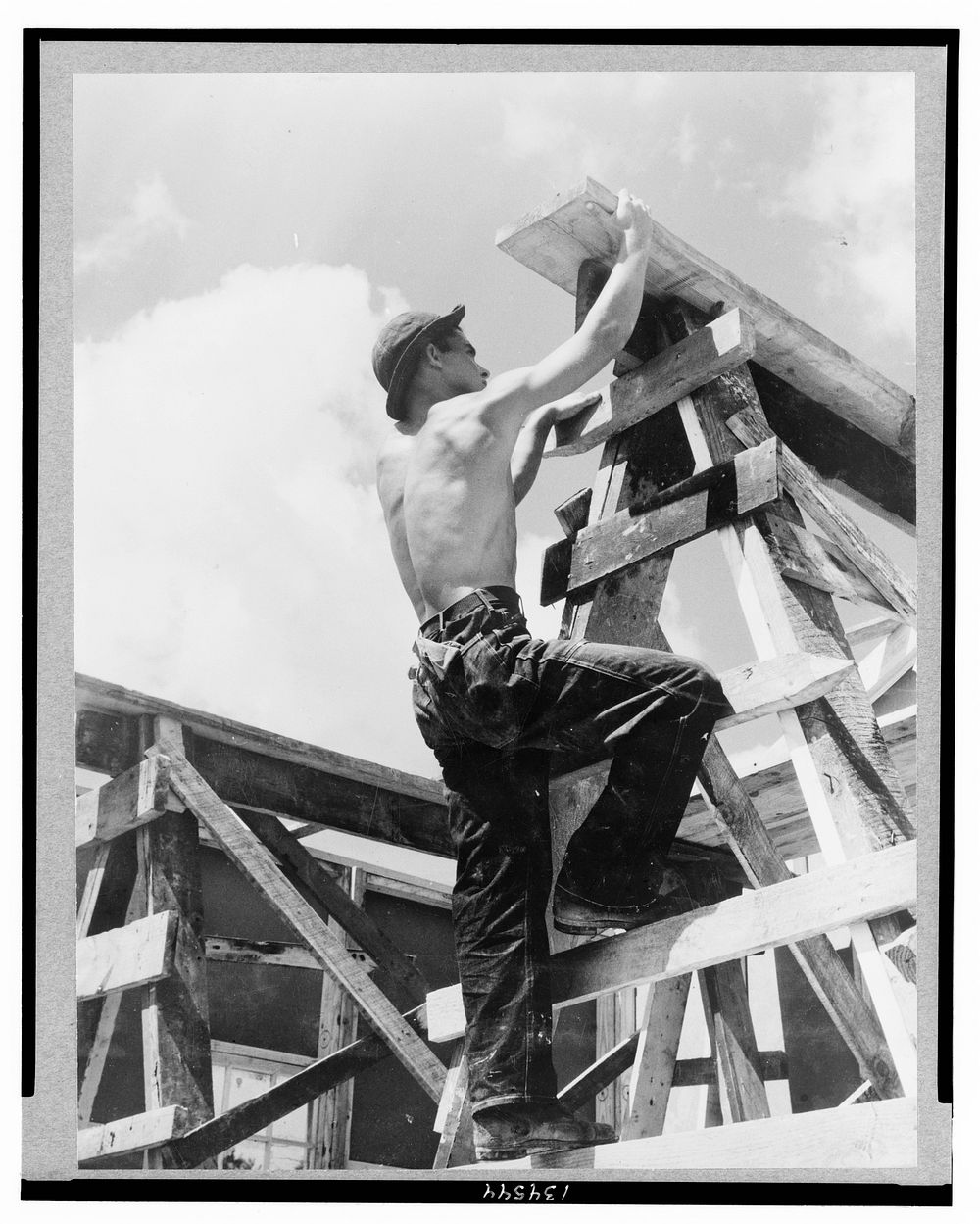 Work projects: Enrollee William L. Cross, Appalachia, Va., climbing up on scaffold erected for assembling a prefabricated…