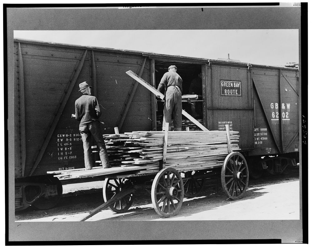 Unloading lumber at sash and door mill, Dubuque, Iowa. Sourced from the Library of Congress.