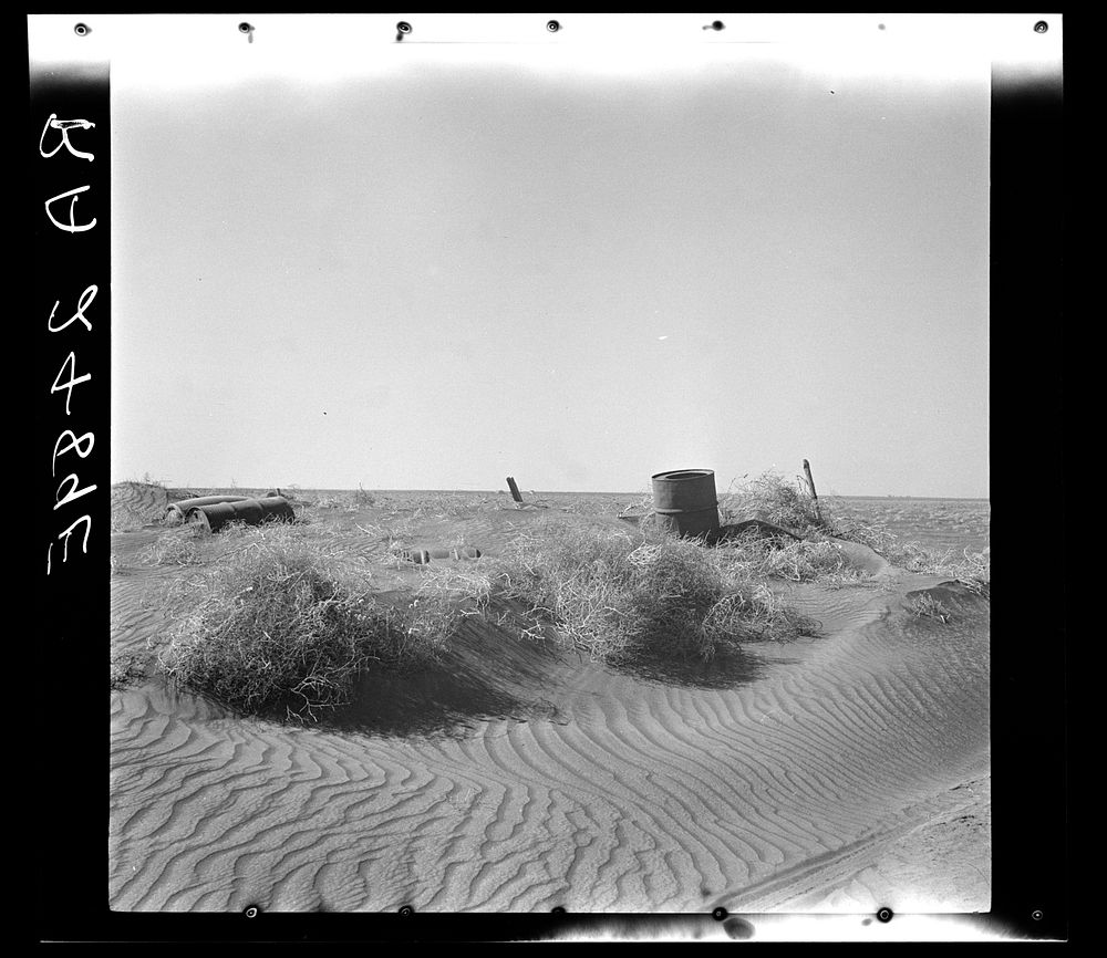 Fence almost completely buried under drifts of soil. Near Liberal, Kansas. Sourced from the Library of Congress.