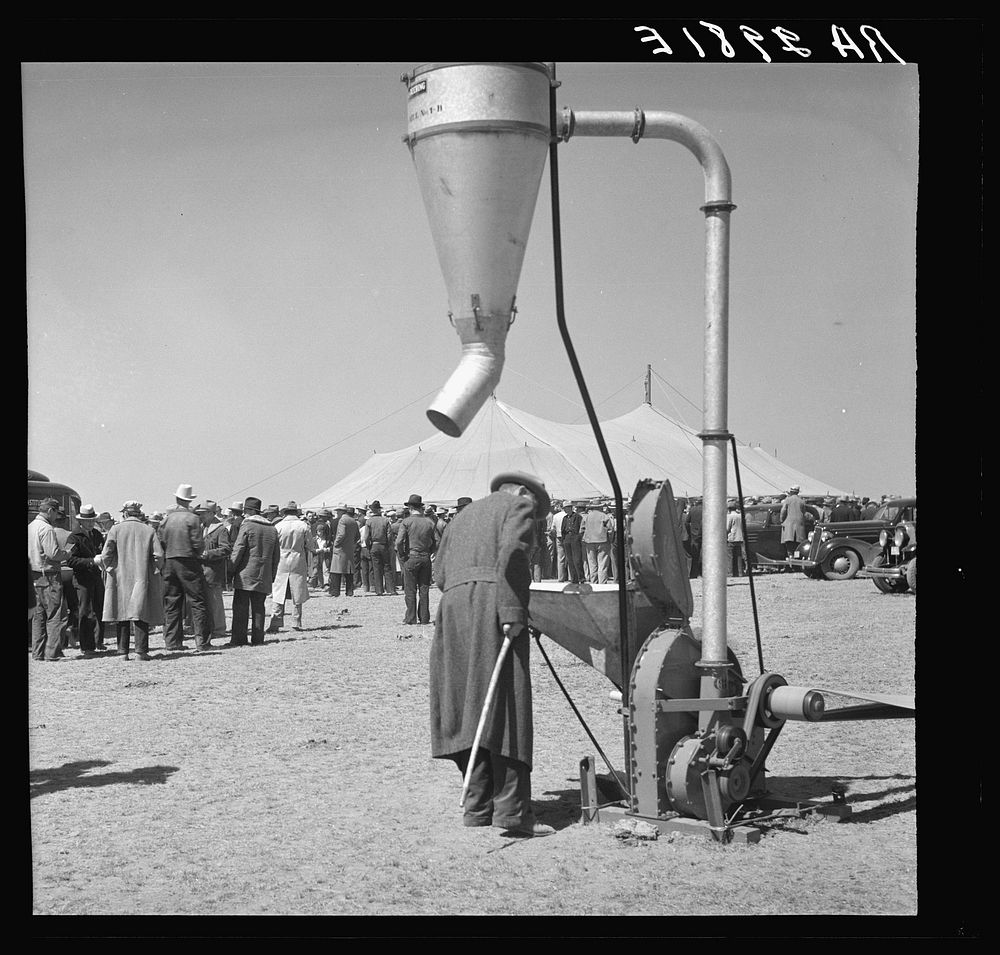 Examining farm machinery. Farm implement show. Carson County, Texas. Sourced from the Library of Congress.