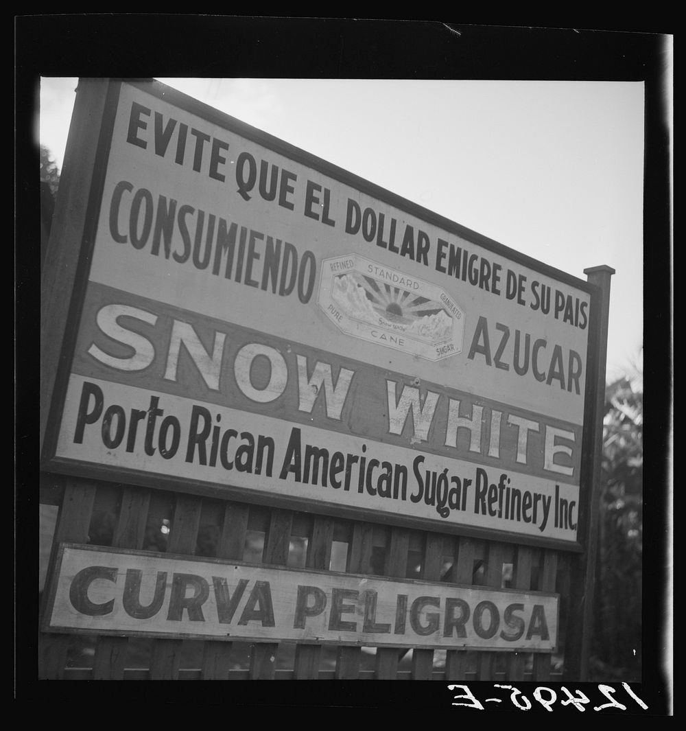 Road sign, "Do not let the dollar emigrate from your country," between San Juan and Ponce, Puerto Rico. Sourced from the…