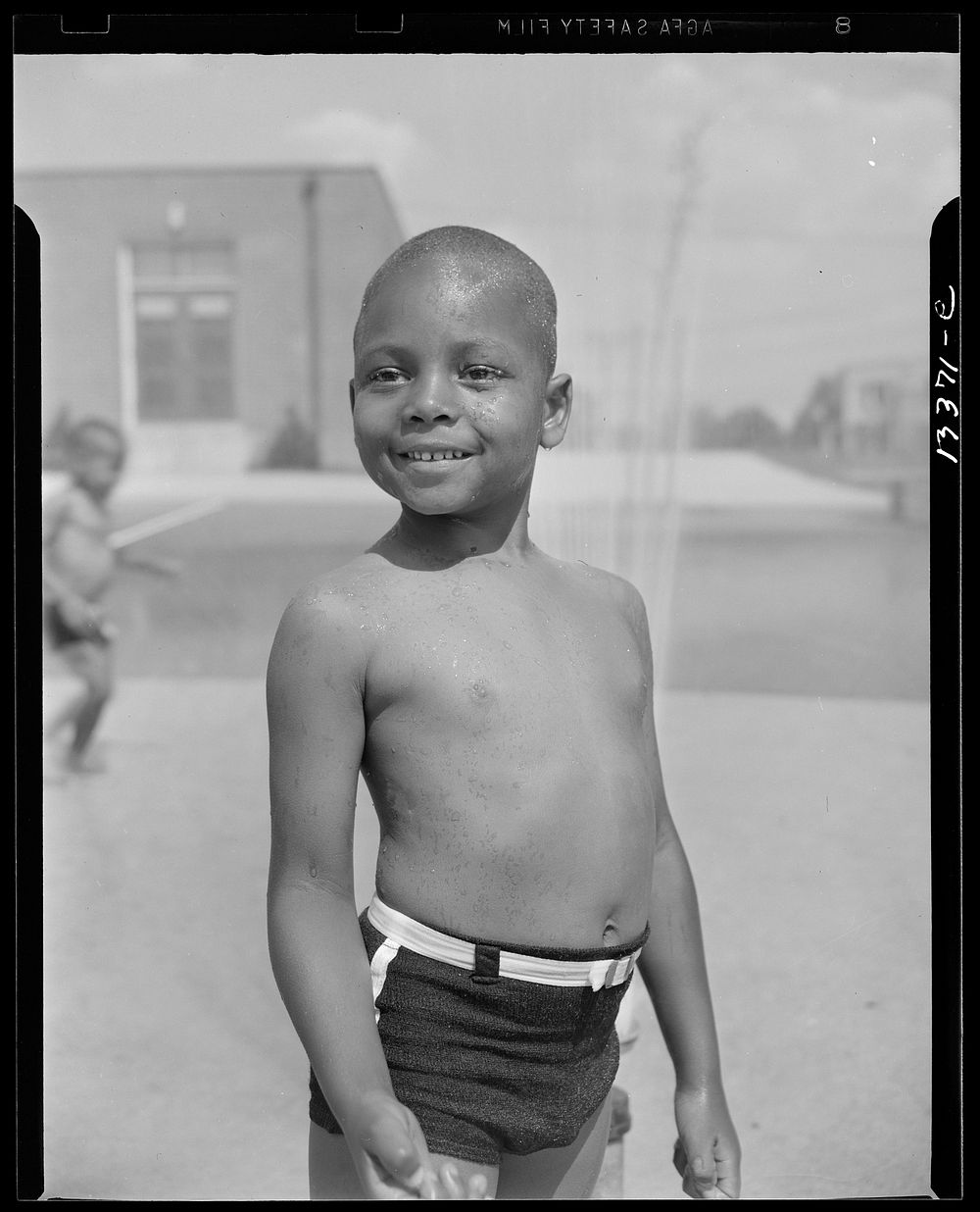 Anacostia, D.C. Frederick Douglass housing project. Cooling off under the community sprayer. Sourced from the Library of…