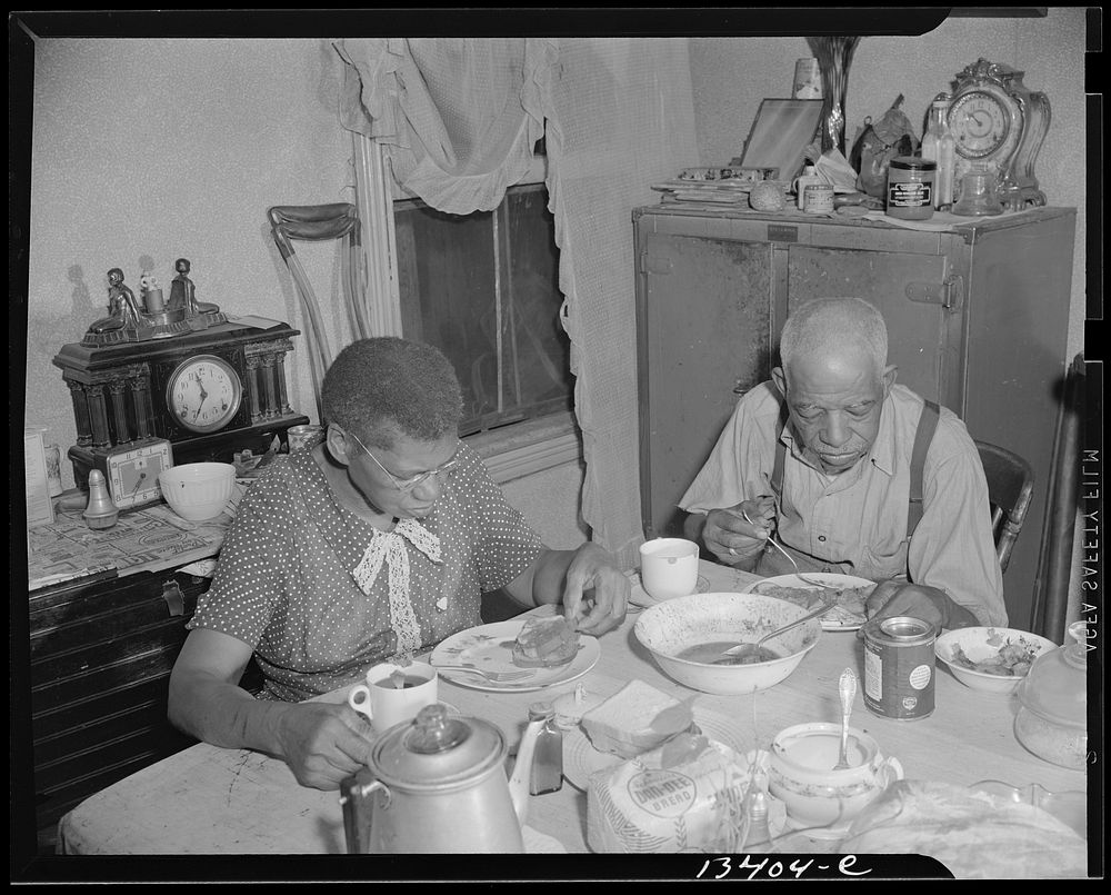 Washington, D.C. Elderly couple eating dinner at their home on Lamont Street, N.W.. Sourced from the Library of Congress.