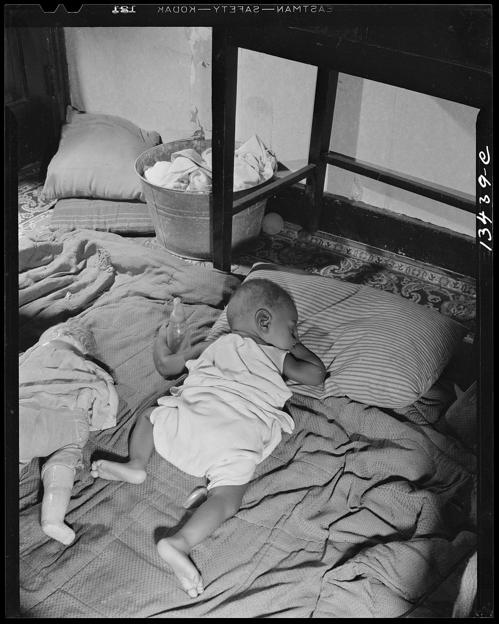 Washington, D.C. Grandchild of Mrs. Ella Watson, a government charwoman, taking her afternoon nap. Sourced from the Library…