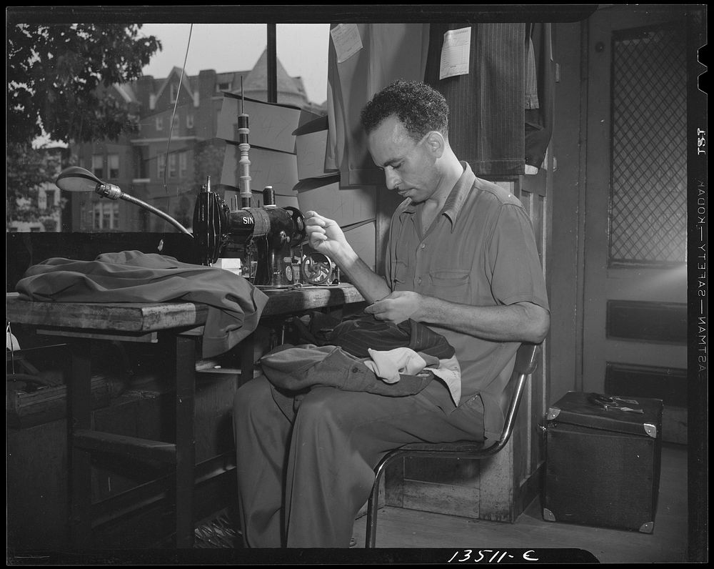 Washington, D.C. A tailor in Frank's cleaning and pressing establishment altering a pair of pants for a customer. Sourced…