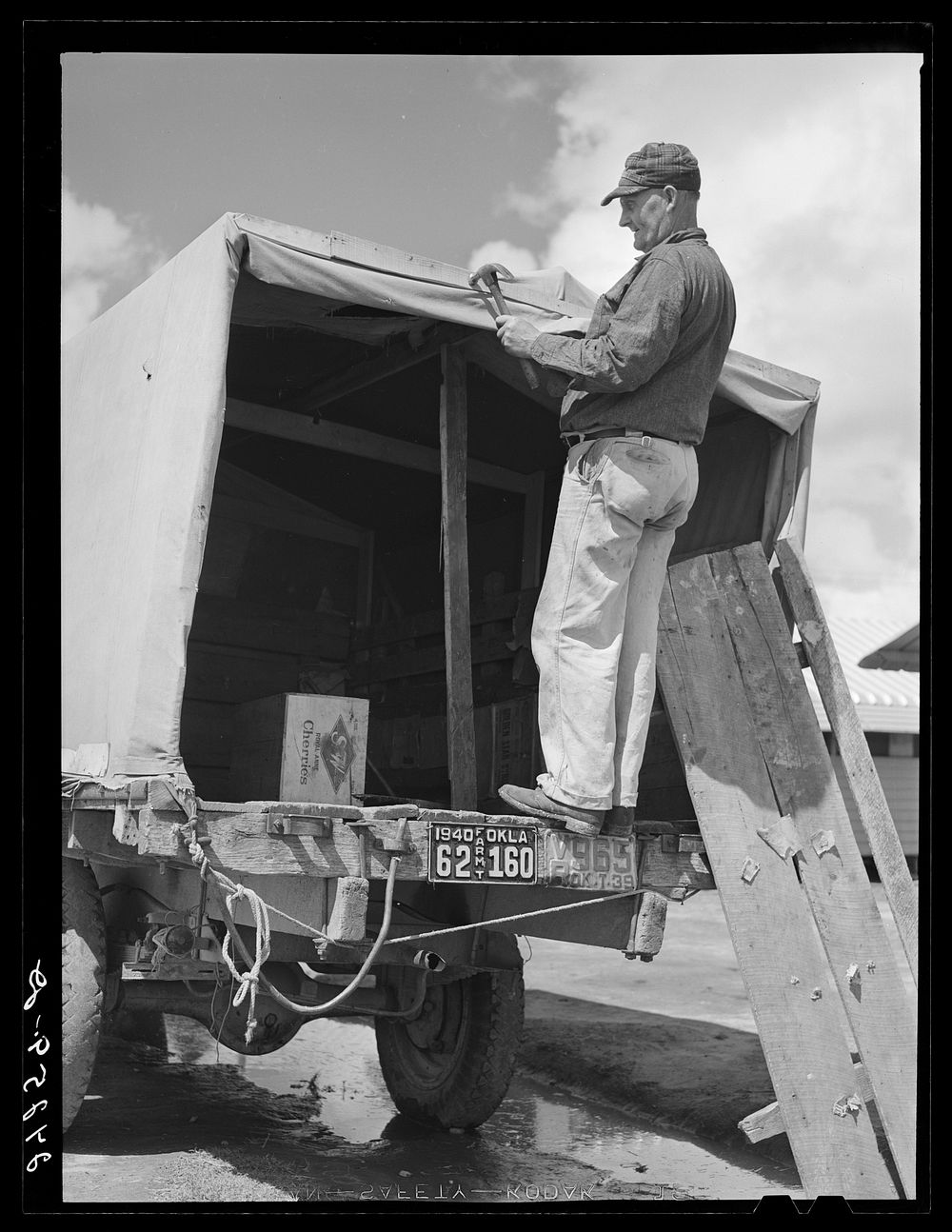 Man repairing truck. Returning to Oklahoma. Tulare migrant camp. Visalia, California. Sourced from the Library of Congress.