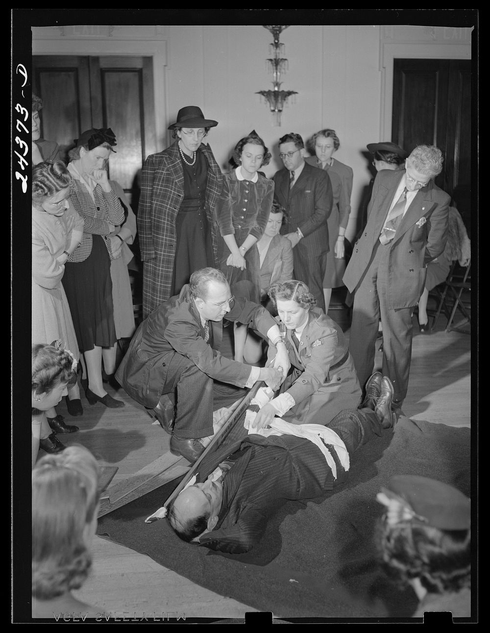 Demonstrating the placing of a splint on a fractured arm. American Red Cross headquarters. New York City. Sourced from the…