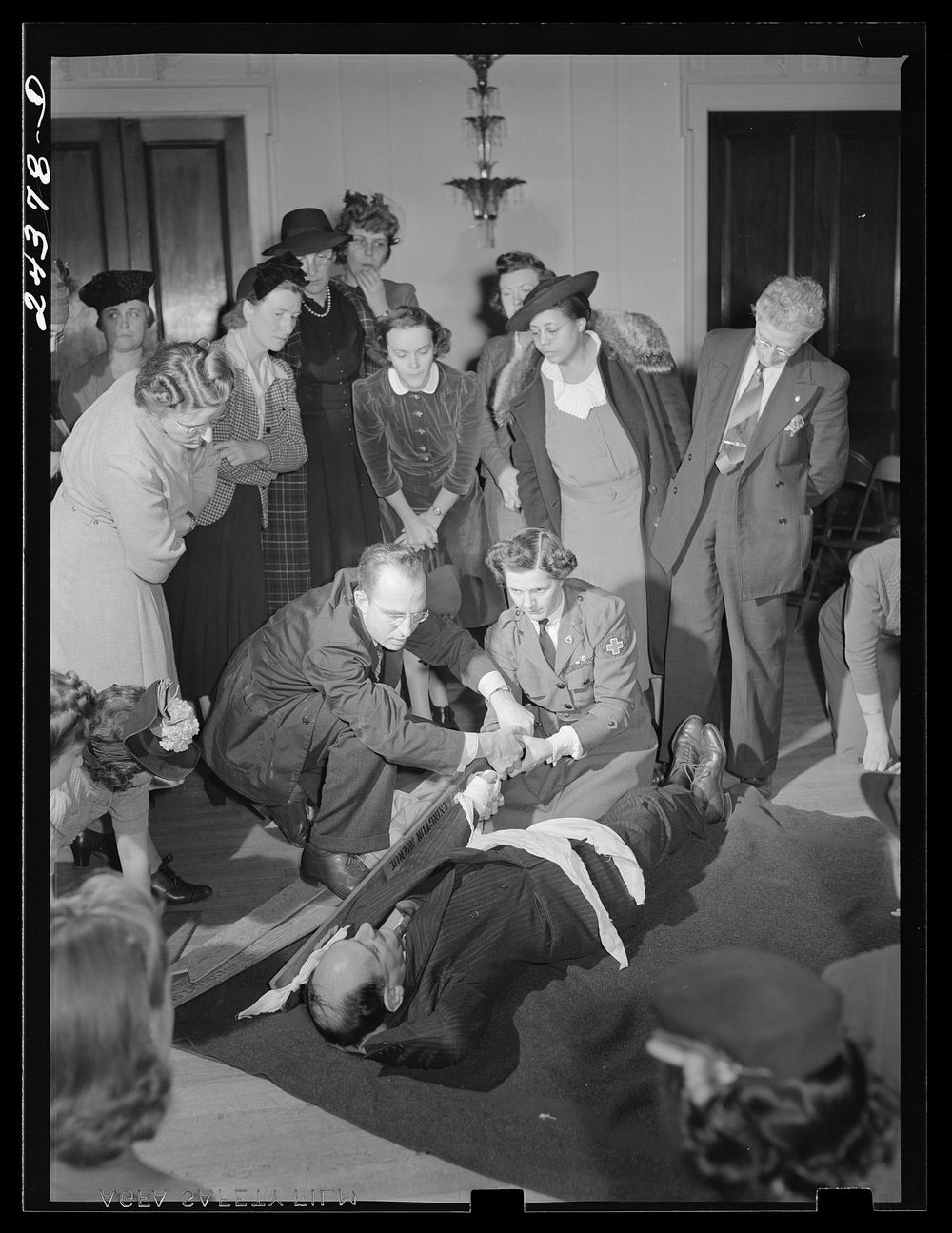 First aid class, American Red Cross, New York City. Demonstrating splint on fractured arm. Sourced from the Library of…