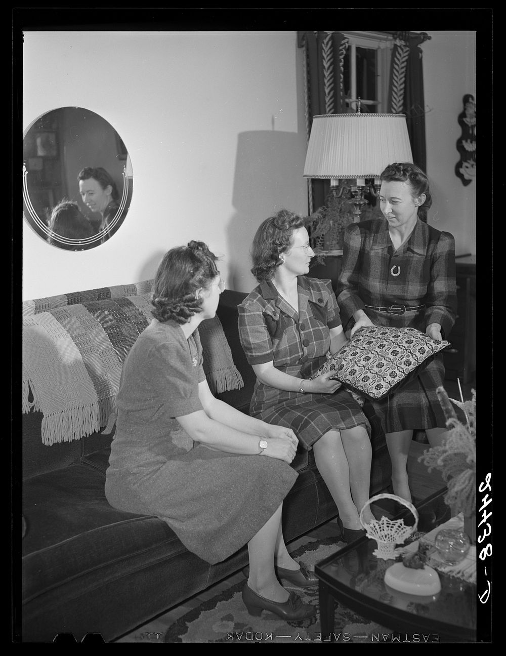 Mrs. Hardeman at home showing some of her handiwork to Miss Linger, project secretary. Dailey, West Virginia. Sourced from…