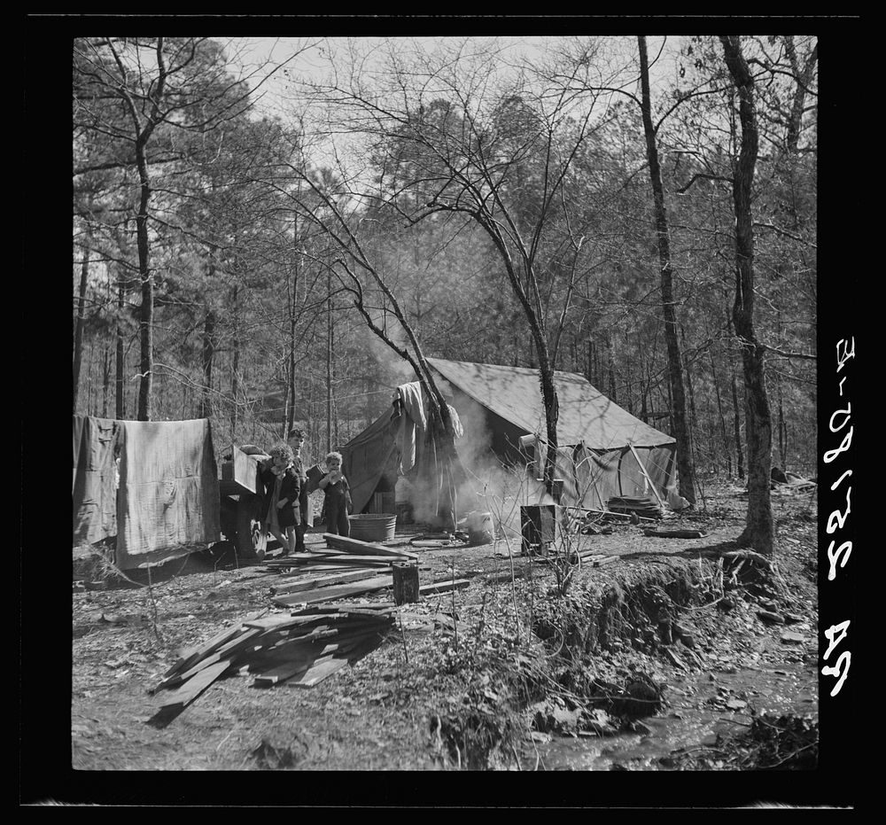 Tent occupied by sharecropper family now living in a migrant camp near Birmingham, Alabama. Note water supply at right.…