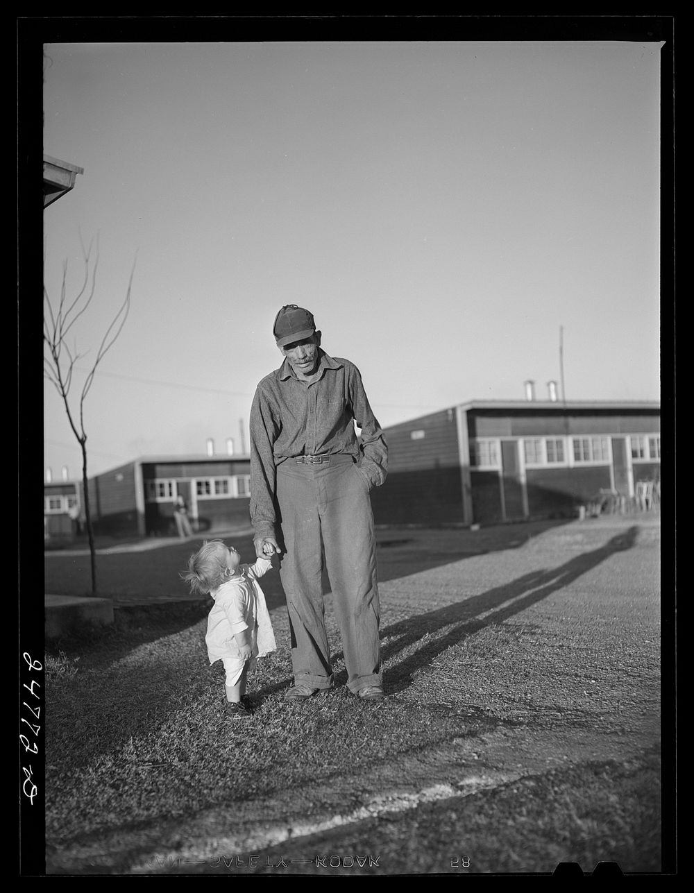 Old farm worker and grandchild. FSA (Farm Security Administration) camp, Robstown, Texas. Sourced from the Library of…