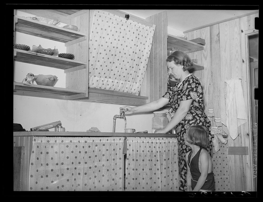 Resettled farmer's wife and daughter in kitchen of new home. Wabash Farms, Indiana. Sourced from the Library of Congress.
