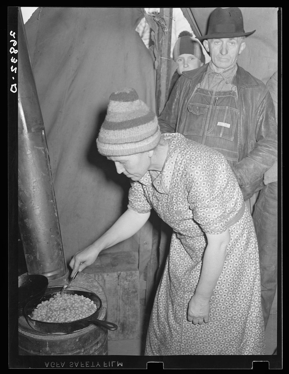 Wife of evicted sharecropper in tent along highway cooking beans obtained from surplus commodities. New Madrid County…