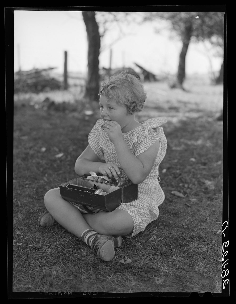 Schoolgirl, pupil of one-room schoolhouse, eating lunch. Grundy County, Iowa. Sourced from the Library of Congress.