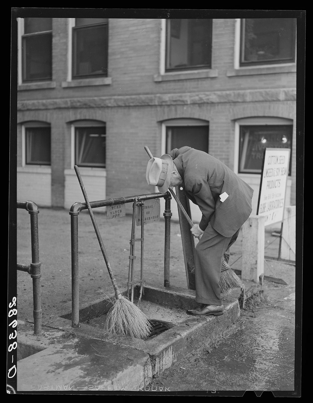 Cattle buyer cleaning his shoes after trip through the stockyards. Denver, Colorado. Sourced from the Library of Congress.