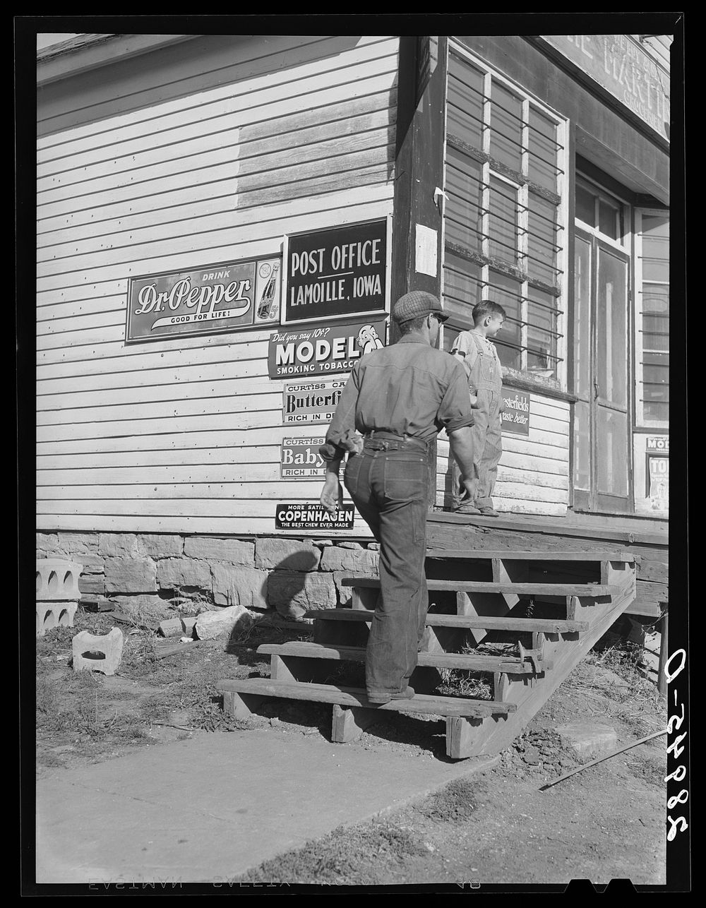 [Untitled photo, possibly related to: Carrying bags of flour out of general store. Lamoille, Iowa]. Sourced from the Library…