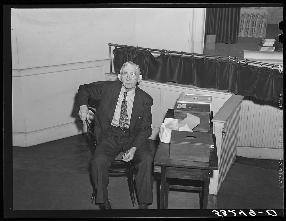 The former sheriff of Woodstock, Vermont, guarding the ballot boxes while he eats his lunch during town meeting noon recess.…