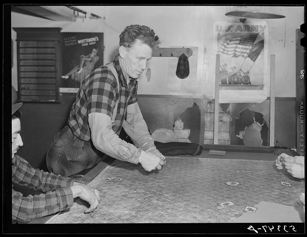 Farmer and townspeople have more leisure time to play cards in pool room during winter months. Woodstock, Vermont. Sourced…
